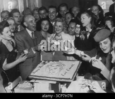 Earl Carroll, der seinen x-ten Geburtstag feiert, verteilt einige seiner Gäste am Tag-Ende einer Party letzte Nacht, die verschwenderischer ist als Hollywood seit Jahren gesehen hat. Bis auf den Kuchen blieb Carrol den größten Teil des Abends in seinem dreistöckigen Herrenhaus zurückgezogen. September 1945. (Foto von AP Wirephoto) Stockfoto