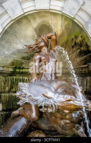 Court of Neptune Fountain Bronze Sculpture Library of Congress Washington DC // WASHINGTON DC – der Court of Neptune Fountain, eine Bronzeskulptur von Roland Hinton Perry, befindet sich an der Vorderseite des Library of Congress Thomas Jefferson Building. Der Brunnen zeigt Neptun, den König des Meeres, mit seinen Söhnen, den Tritonen, Nymphen, die als Nereiden bekannt sind, und verschiedene Meeresbewohner. Perry, der 27 Jahre alt war, als er das Werk fertigstellte, ließ sich vom Trevi-Brunnen in Rom inspirieren. Die Bronzefiguren wurden von Henry-Bonnard Bronze Co. Gegossen und 1898 installiert. Albert Weinert vollendete das Skulpturensemble von c Stockfoto