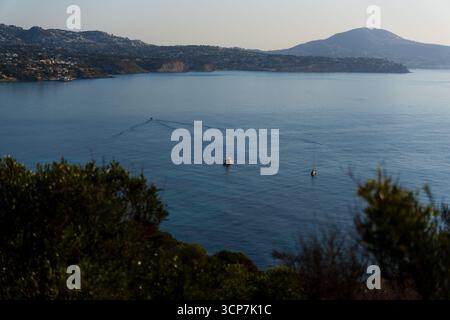 Blick auf die Bucht von Calpe: Drei Yachten auf dem ruhigen Meer, mit Cap Blanc und Bergen im Hintergrund Stockfoto