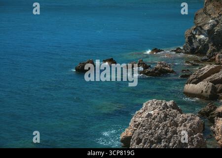 Das Bild zeigt einen atemberaubenden Blick auf felsige Klippen mit Blick auf das ruhige blaue Meer. Westküste des Golfs von Antalya im Süden der Türkei. Hochwertige Fotos Stockfoto
