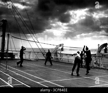 S.S. America's Stag Cruise -- Deck Tennis auf dem Sportdeck hält einige der Passagiere während des Gastes der S.S. America lebendig: (Am anderen Ende, von links nach rechts) Paul Wollan und Charles Cole von Pan American Airways kämpfen gegen C.P. Troxell und A. C. Sorensen von der Maritime Commission. Dezember 1946. (Foto von Wide World Photos). Stockfoto