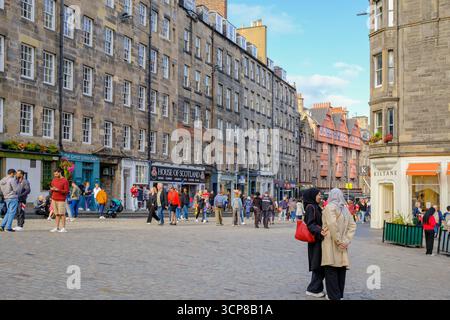 Touristen genießen die Abendsonne auf dem Lawnmarket auf der Royal Mile, Edinburgh, Schottland – ein lebhaftes Wahrzeichen der Altstadt. Stockfoto
