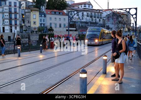 Fußgänger und Touristen auf der oberen Ebene der Dom Luis I Brücke warten auf die Straßenbahn in Porto, Portugal Stockfoto