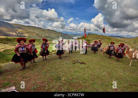 In ihren wunderschön gewebten Kleidungsstücken versammeln sich die Menschen von Chinchero zu einer fröhlichen Feier der Kultur, des kulturellen Erbes und der Gemeinschaft. Stockfoto