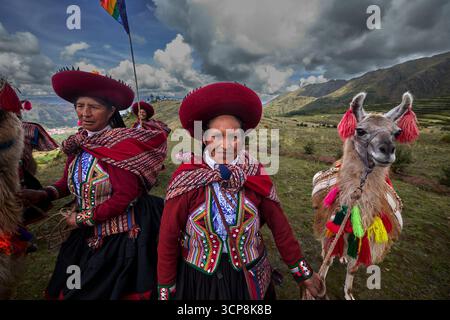 In ihren wunderschön gewebten Kleidungsstücken versammeln sich die Menschen von Chinchero zu einer fröhlichen Feier der Kultur, des kulturellen Erbes und der Gemeinschaft. Stockfoto