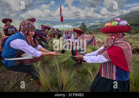 In ihren wunderschön gewebten Kleidungsstücken versammeln sich die Menschen von Chinchero zu einer fröhlichen Feier der Kultur, des kulturellen Erbes und der Gemeinschaft. Stockfoto
