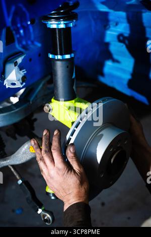 Scheibenbremse und Federbein werden für Driftrennen optimiert. Einbau der Vorderradaufhängung und der Bremsscheibe. Bremsscheibe und Strebe für Leistung Stockfoto