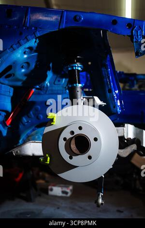 Einbau der Vorderradaufhängung und der Bremsscheibe. Leistungsfähige Bremsscheibe und Federbein für die Kraftabschaltung der Drift montiert. Scheibenbremse und Spannschraube Stockfoto