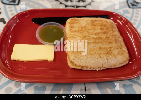 Butter und kaya-Weizen toasten auf einem roten Teller. Stockfoto