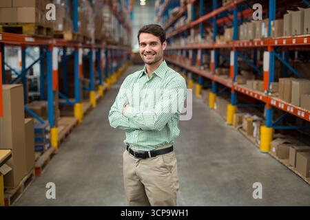 Regale säumen die Gänge des Lagers und halten gestapelte Kartons unter Deckenleuchten Stockfoto