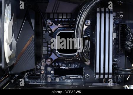 Close-up-Kühlpumpe auf CPU-Sockel und Quad-Channel-RAM DDR4, die auf einem modernen Mainboard, im Desktop-PC-Gehäuse und im Heimwerker-Computer installiert ist Stockfoto