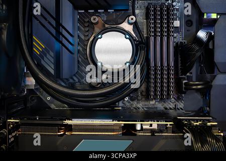 Close-up-Kühlpumpe auf CPU-Sockel und Quad-Channel-RAM DDR4, die auf einem modernen Mainboard, im Desktop-PC-Gehäuse und im Heimwerker-Computer installiert ist Stockfoto