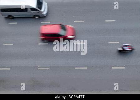 Die Bewegung verschwimmt, wenn sich das Auto auf der Straße bewegt, mit Geschwindigkeit auf der Draufsicht, Hintergrund Stockfoto