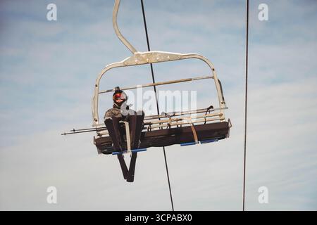 Teenager-Skirennbahn im Skigebiet mit Helmkamera, Skibrille und Skiern Stockfoto