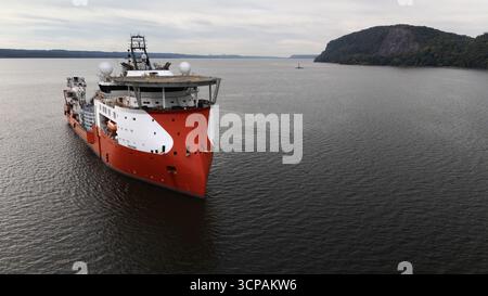 Nyack, USA - 16. September 2025: Aus der Vogelperspektive eines markanten rot-weißen Schiffes, das durch das dunkle Wasser des Hudson River schneidet, mit dem V Stockfoto