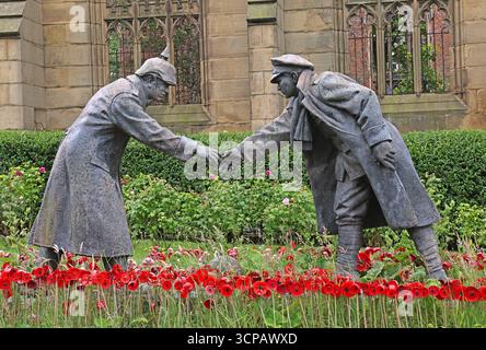 Skulptur, die zwei Soldaten aus dem Ersten Weltkrieg zeigt, die die Hand schütteln, um an den Weihnachtsstillstand von 1914 zu erinnern, der in der bombardierten Kirche St. Lukes installiert wurde Stockfoto