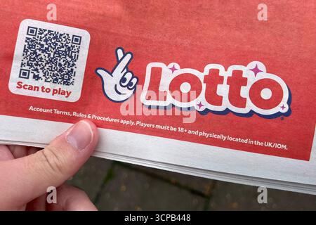 Lotto Scan to Play Werbung mit dem neuen National Lottery Logo auf einer Zeitung. September 2025. Stockfoto