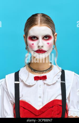 Eine kreative junge Frau glänzt in einem Halloween-Kostüm und Make-up mit Clown-Motiv. Stockfoto
