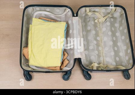 Ein ordentlich verpackter Koffer mit bunten gefalteten Kleidungsstücken, ideal als Inspiration für Ihr nächstes Reiseabenteuer Stockfoto