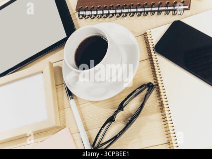 Kaffee und Notizbücher auf einem Holztisch während einer Arbeitssitzung Stockfoto