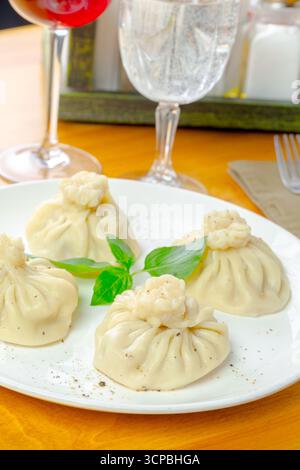Köstliche Teigtaschen serviert auf einem weißen Teller in einem gemütlichen Restaurant Stockfoto
