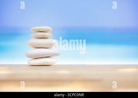 Wunderschöne Zen-Steine in weichem Sand. Inspirierender Meditationsstrand mit verschwommenem Horizont am Meer. Wunderschönes Naturmuster, Zen Spa Peace Konzept Stockfoto