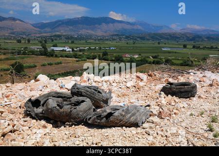 Verlassene Autoreifen und ländliche Landschaft in der Nähe von Sarande, Albanien. Illegaler Müll auf dem albanischen Land. Stockfoto