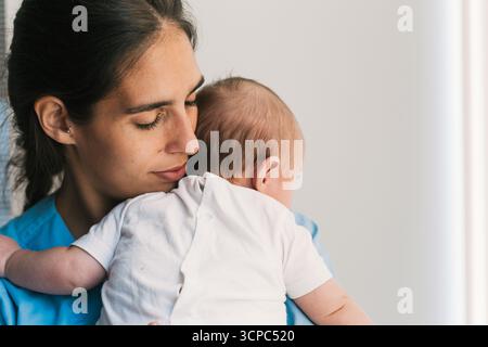 Schwester hält ein Neugeborenes im Krankenhauszimmer Stockfoto