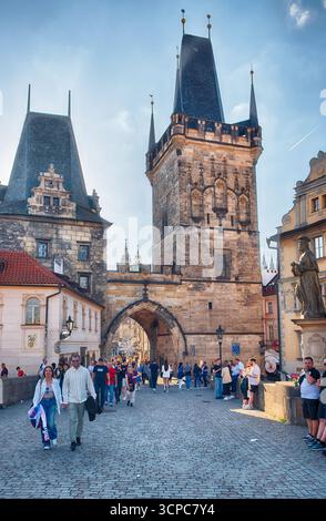 PRAG - 10. MAI 2024: Touristen spazieren unter dem kleinen Karlsbrückenturm an einem sonnigen Tag in Prag, Tschechien Stockfoto