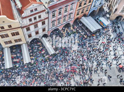 PRAG - 10. MAI 2024: Touristen wandern auf dem Altstadtplatz in Prag, Tschechien, mit seinen kopfsteingepflasterten Straßen und farbenfrohen Gebäuden Stockfoto