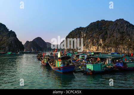 Cat Ba, Vietnam - 20. März 2025: Traditionelle vietnamesische Fischerboote in der Bucht von Lan Ha Long. Wunderschöne Kalksteinkarstinseln, türkisfarbenes Meerwasser. Stockfoto
