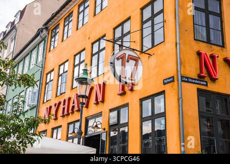 Orange Building mit Neonbeschilderung in Nyhavn, Kopenhagen, Dänemark Stockfoto