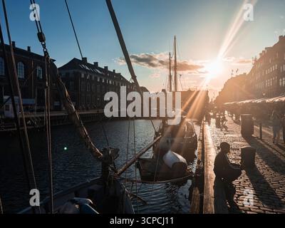 Nyhavn Waterfront in Kopenhagen, Dänemark bei Sonnenuntergang mit vertäuten Booten Stockfoto