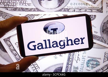 Polen. September 2025. In dieser Fotoabbildung wird das Arthur J Gallagher and Co-Logo auf einem Smartphone-Bildschirm mit dem US-Dollar-Schein im Hintergrund angezeigt. (Credit Image: © Piotr SWAT/SOPA Images via ZUMA Press Wire) NUR REDAKTIONELLE VERWENDUNG! Nicht für kommerzielle ZWECKE! Stockfoto