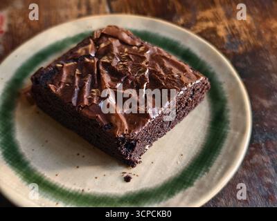 Ein Stück Fudgy Chocolate Brownie auf einer Keramikplatte Stockfoto