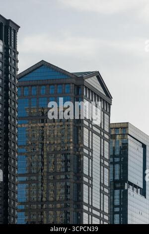 Ein beeindruckender Blick auf moderne Wolkenkratzer mit reflektierenden Glasfassaden vor einem bewölkten Himmel in Chicago, Illinois. Stockfoto