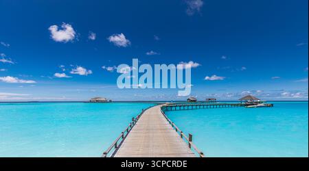Atemberaubende Wasservillen in den Malediven Inseln Resorts mit ruhigem Pier ruhigem Meer Horizont unter sonnigem blauem Himmel. Beliebte tropische Sommerferienlandschaft Stockfoto