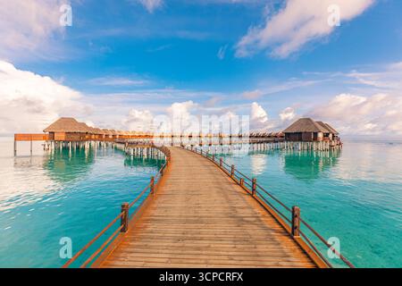 Atemberaubende Wasservillen in den Malediven Inseln Resorts mit ruhigem Pier ruhigem Meer Horizont unter sonnigem blauem Himmel. Beliebte tropische Sommerferienlandschaft Stockfoto