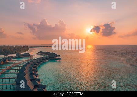 Fantastischer Blick auf das Luxusresort auf den Malediven bei Sonnenuntergang. Wasservillen über der Lagunenbucht des Ozeans, exotisches Sommerziel für tropischen Urlaub. Stockfoto