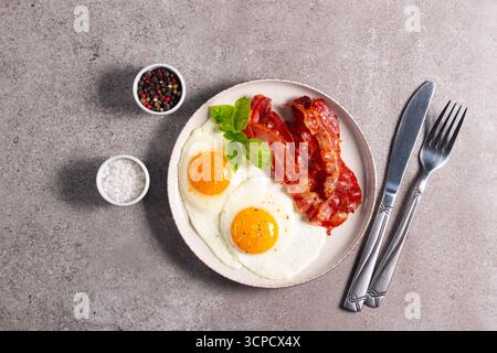 Köstliches traditionelles englisches Frühstück mit Spiegeleiern und Speck Stockfoto