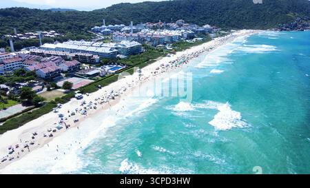 Panoramablick auf Brava Beach in Florianopolis, Santa Catarina, mit dem Sand voller Menschen und dem türkisblauen Meer auf einem wunderschönen Stockfoto