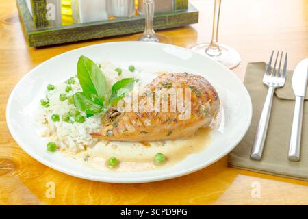Köstliches gegrilltes Lachsfilet serviert mit Reis und Erbsen auf einem Holztisch Stockfoto
