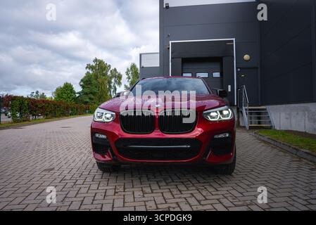 Nahaufnahme der Vorderansicht des roten BMW X4 auf einer asphaltierten Einfahrt Stockfoto