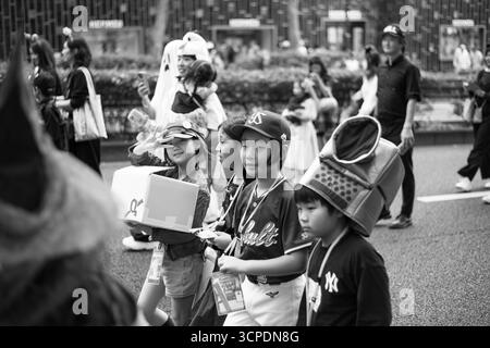 TOKIO, JAPAN - 27. OKTOBER 2024 - Schwarzweißbild japanischer Kinder in typischer Halloween-Kleidung bei Omotesando Halloween in Tokio, Stockfoto