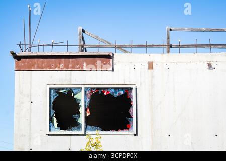 Verlassene Baustelle mit freiliegendem Bewehrungsstahl und beschädigten Fenstern durch Täter. Stockfoto