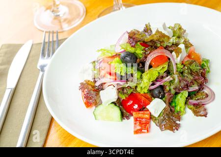 Frischer Gartensalat mit verschiedenen Gemüsesorten auf einem feinen Esstisch Stockfoto