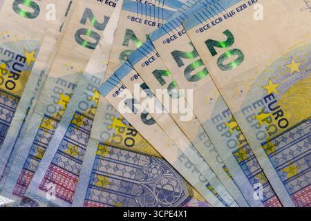 Nahaufnahme von mehreren 20-Euro-Banknoten, aufgefächert, um ihre Merkmale zu zeigen. Vorherrschende Farben sind hellbeige, blau, gelb und leicht rosa Details. Stockfoto