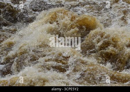 Rauschendes Wasser an den Falls of Dochart, Killin, Schottland. Nahaufnahme der turbulenten Stromschnellen im August, die die Kraft und Bewegung zeigen. Stockfoto