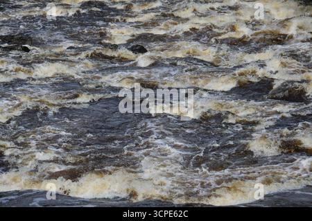 Rauschendes Wasser an den Falls of Dochart, Killin, Schottland. Nahaufnahme der turbulenten Stromschnellen im August, die die Kraft und Bewegung zeigen. Stockfoto