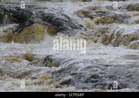 Rauschendes Wasser an den Falls of Dochart, Killin, Schottland. Nahaufnahme der turbulenten Stromschnellen im August, die die Kraft und Bewegung zeigen. Stockfoto